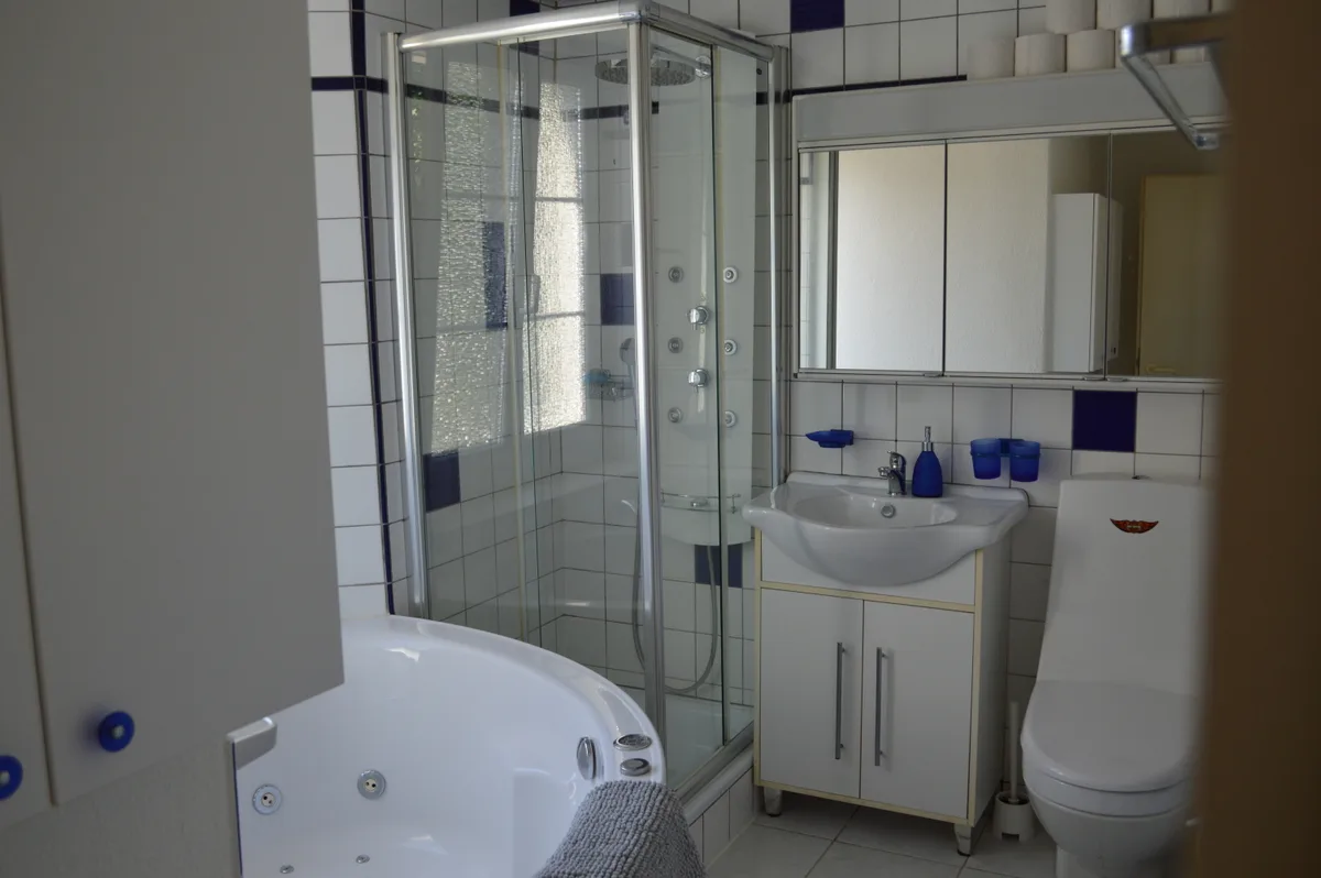 Ein Badezimmer ganz in weiss, mit blauen Akzenten.